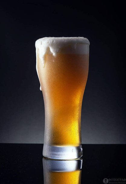 Glas bier op zwarte achtergrond - Foto, afbeelding