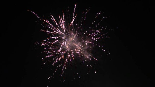 Oranje wazig vuurwerk lichten op zwarte lucht achtergrond. Concept van Nieuwjaar en Kerstmis. - Foto, afbeelding