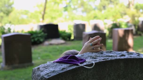 Femme priant près de la pierre tombale avec masque  - Séquence, vidéo