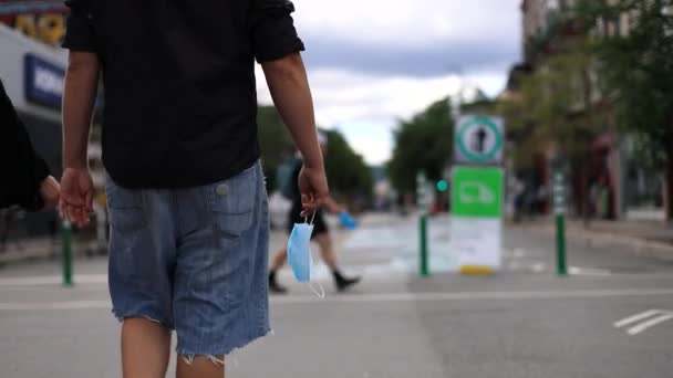 Człowiek ręce trzymając maskę podczas chodzenia - Materiał filmowy, wideo
