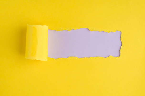 Topo acima vista aérea foto de papel amarelo rasgado sobre fundo lilás claro com copyspace - Foto, Imagem