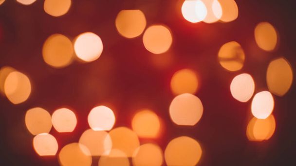 Defocused abstract bokeh lights background. orange, red, black colors. christmas and new year concept - Photo, image