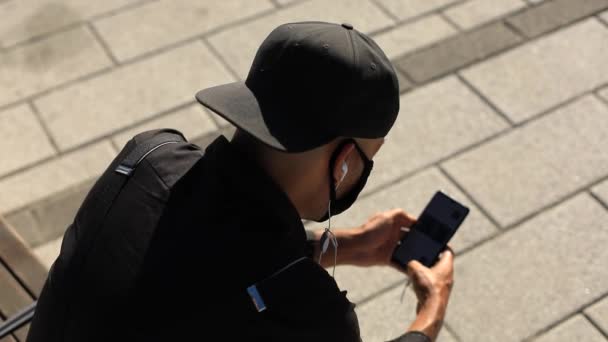 Άντρας με καπέλο και ακουστικό με κινητό - Πλάνα, βίντεο