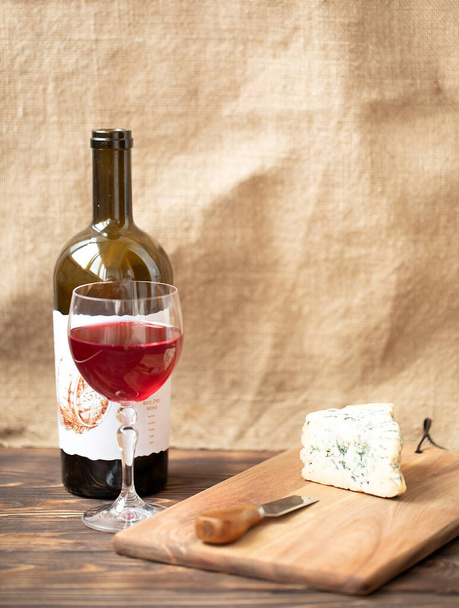 Wine with glass and dor blu cheese on wooden board with knife - Foto, immagini