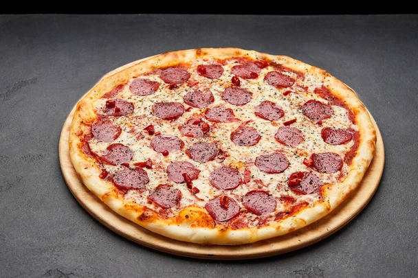 Delicious Italian Pizza pepperoni with mozzarella cheese and salami on dark background - Photo, Image