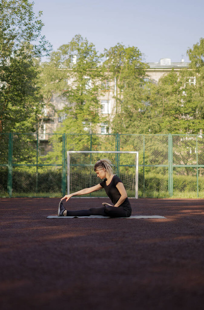 Young fitness girl doing stretching and yoga on a playground - Foto, immagini