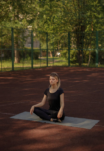 Young fitness girl doing stretching and yoga on a playground - Zdjęcie, obraz