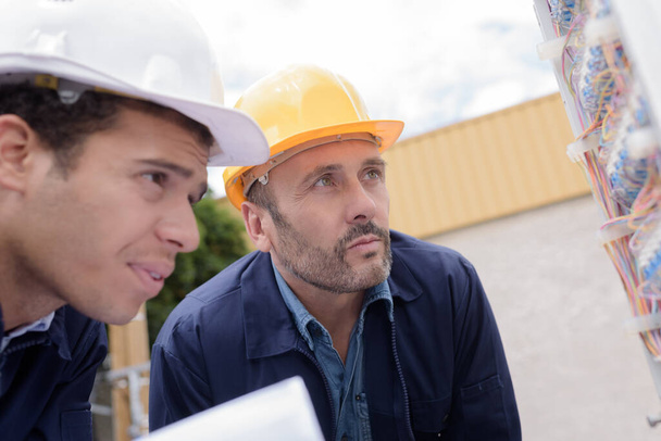 two technician workers adjusting cables outdoors - Photo, image