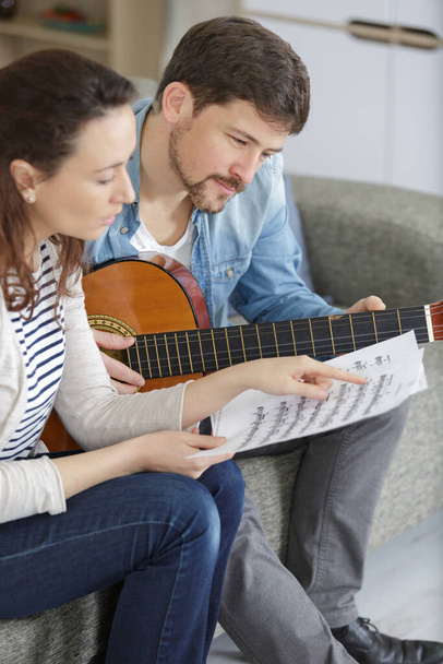 young people playing guitar together at home - Foto, afbeelding