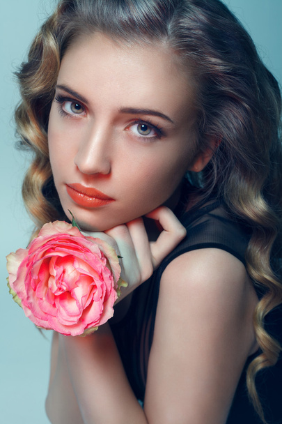 Portrait of a girl with a flower in hand - Фото, изображение
