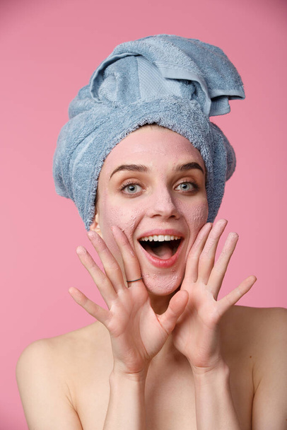 Beauty treatment - woman applying clay face mask - 写真・画像