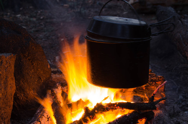 fire burns in the campaign. pot of tea by the fire - Fotoğraf, Görsel