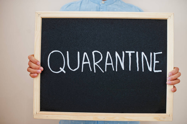 Quarantine. Coronavirus concept. Boy hold inscription on the board. - Фото, изображение