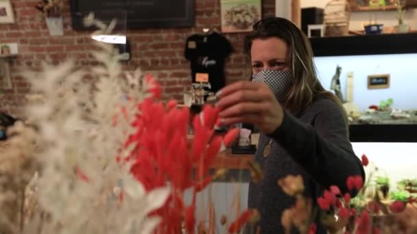 Nainen naamio etsivät kasveja kukkakauppa - Materiaali, video