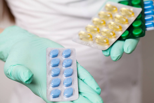 Крупним планом жінка-лікар тримає таблетки для здоров'я чоловіків
 - Фото, зображення