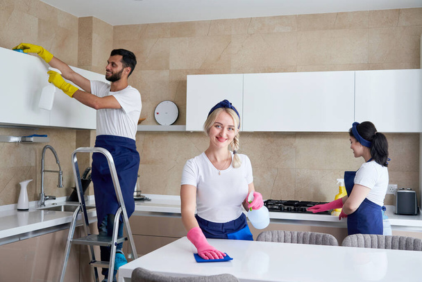 Servizio di pulizia team al lavoro in cucina in casa privata - Foto, immagini