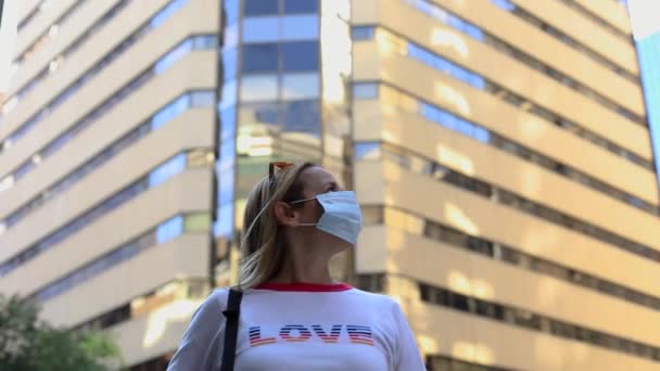 Νεαρή γυναίκα που φοράει μάσκα μετακομίζει στην πόλη - Πλάνα, βίντεο