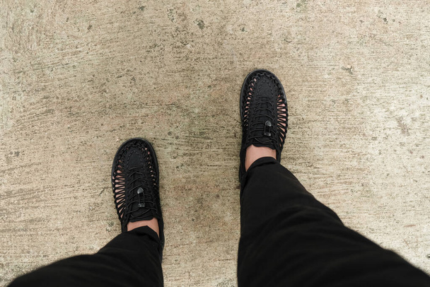 Un hombre caminando con zapatos negros en la calle  - Foto, Imagen