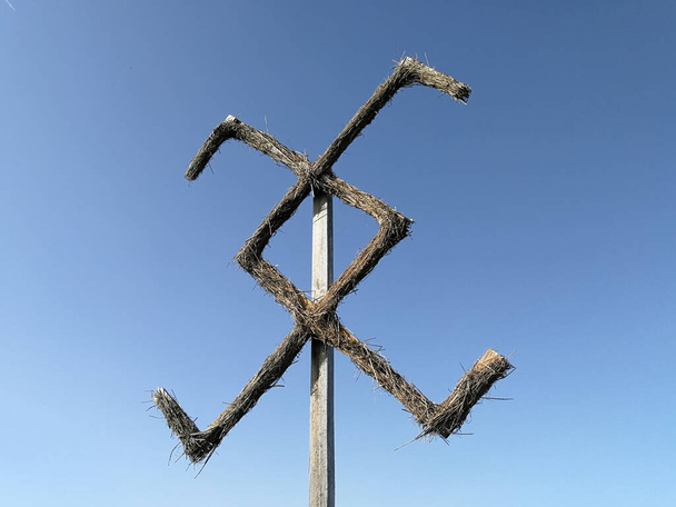 Starý litevský baltský pohanský symbol vyrobený z čau před modrou oblohou - Fotografie, Obrázek
