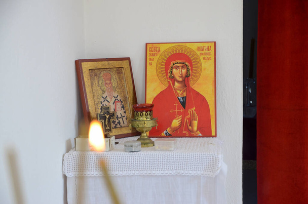 Świece przed ikonami w cerkwi prawosławnej. Płonące świece woskowe, krzyż i ikony w klasztorze - Zdjęcie, obraz