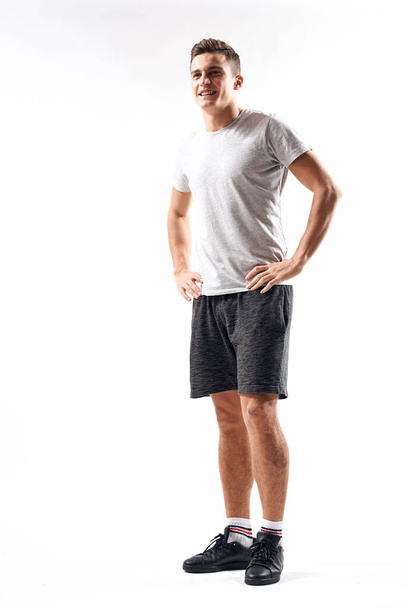 Athletic man on a light background in full growth and jogging charging shorts sneakers t-shirt - Photo, image