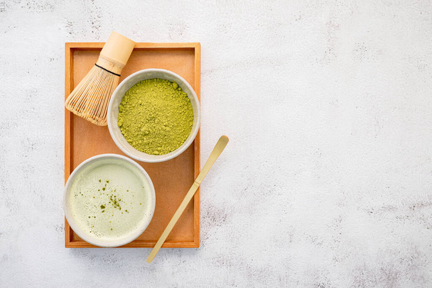 Matcha zielona herbata w proszku z bambusa matcha zestaw szczotki do trzepaczki na białym tle betonu . - Zdjęcie, obraz
