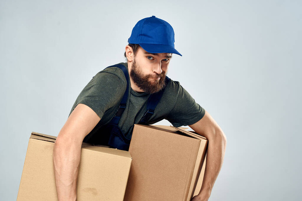 Man in werkuniform met dozen in handen levering laden levensstijl - Foto, afbeelding