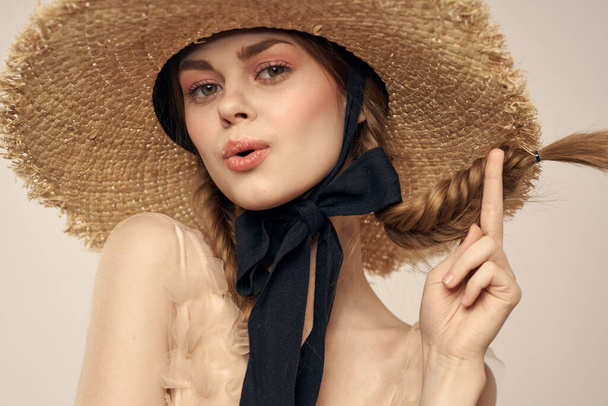 Nice girl in a straw hat with a black ribbon and in a dress on a light background romance model fun emotion - Φωτογραφία, εικόνα