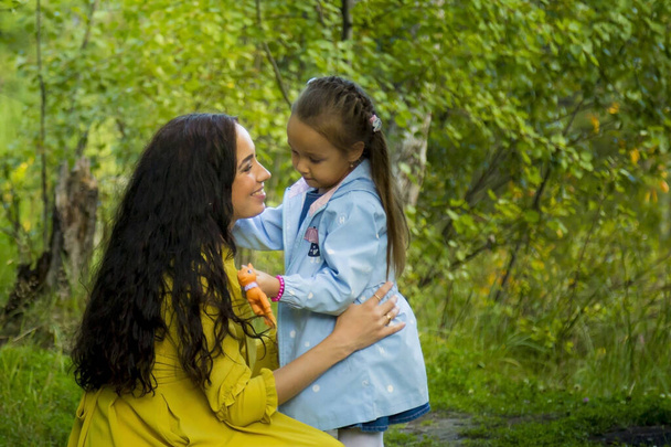 Πορτραίτο εγκύου με κίτρινο φόρεμα με την κόρη της στο φθινόπωρο του δάσους - Φωτογραφία, εικόνα