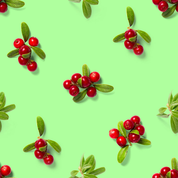 Lingonberry patrón sin costuras sobre fondo verde. Bayas o arándanos frescos con hojas como patrón sin costuras para textiles, tejidos, estampados o carteles - Foto, imagen