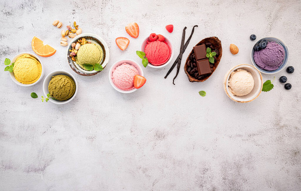 Vari gusti di gelato in ciotola mirtillo, tè verde, cocco, fragola e cioccolato setup su sfondo pietra bianca . - Foto, immagini