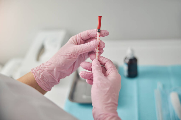 Nainen kosmetologi kädet tilalla kertakäyttöinen lääketieteellinen ruisku - Valokuva, kuva