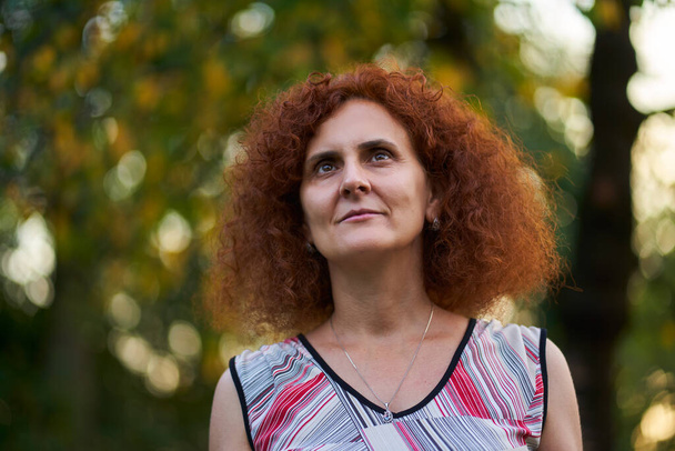 Curly redhead woman outdoor in the countryside, candid portrait - Φωτογραφία, εικόνα