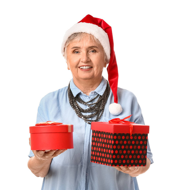 Mujer mayor con regalos de Navidad sobre fondo blanco - Foto, Imagen