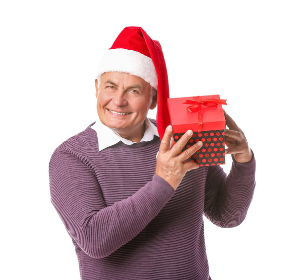Elderly man with Christmas gift on white background - Photo, Image
