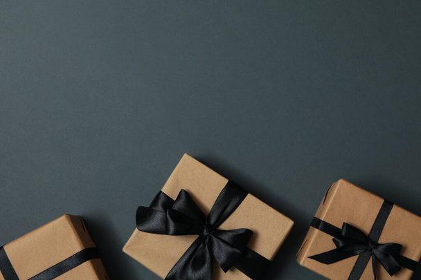 Виготовлення подарункових коробок з бантом на сірому фоні
 - Фото, зображення