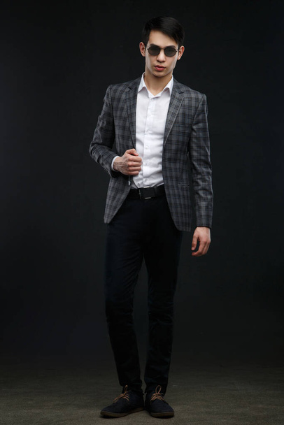 Young asian businessman isolated on a dark background. - Фото, зображення