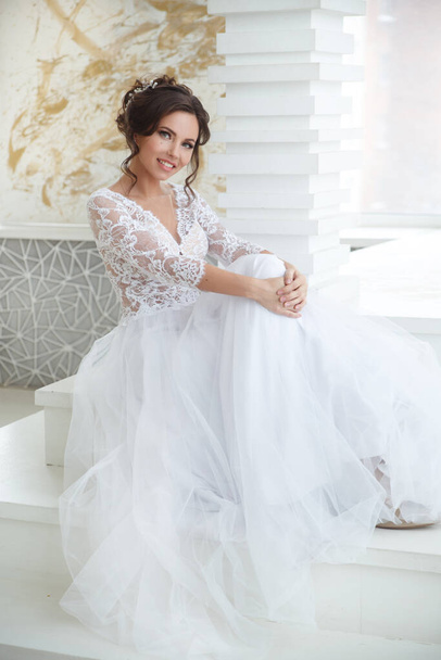 Beautiful girl bride in a long lace dress with an elegant hairstyle. - Foto, immagini