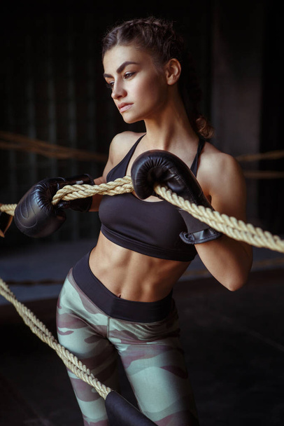 Beautiful slim sexy sportswoman in the ring and the gym in boxing gloves. - Фото, зображення