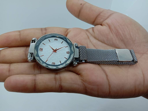 grijs gekleurde horloge closeup op grijze achtergrond - Foto, afbeelding