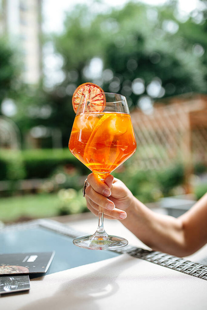 Holding a glass of aperole spritz cocktail - Photo, Image