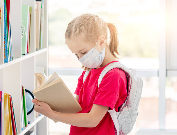 Little girl in school library during pandemic - Foto, imagen