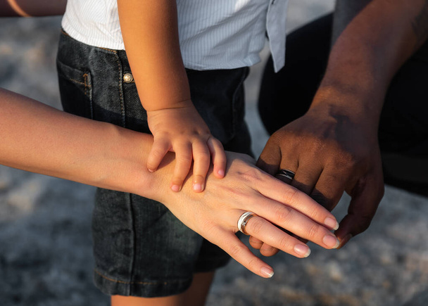 Primo piano di tre multirazziale persona di famiglia impilare i palmi delle mani. Amore multirazziale e integrazione tra diversità - Foto, immagini