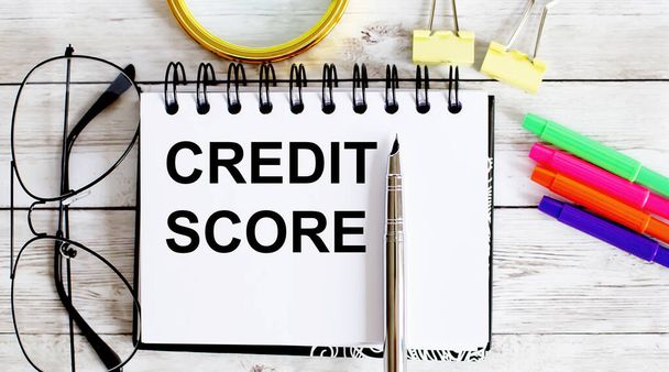 CREDIT SCORE written in notebook on white background with office tools - Photo, Image