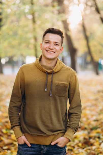 Az őszi parkban mosolygó jóképű fickó portréja - Fotó, kép