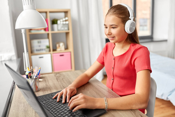girl in headphones with laptop computer at home - Фото, зображення