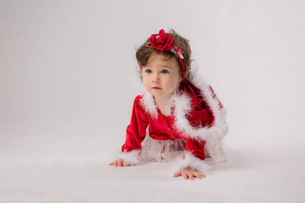 Το χαριτωμένο κοριτσάκι φοράει Χριστουγεννιάτικα ρούχα.  - Φωτογραφία, εικόνα