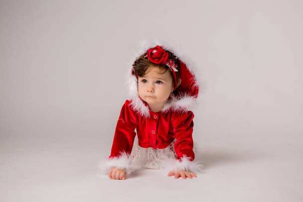 Το χαριτωμένο κοριτσάκι φοράει Χριστουγεννιάτικα ρούχα.  - Φωτογραφία, εικόνα