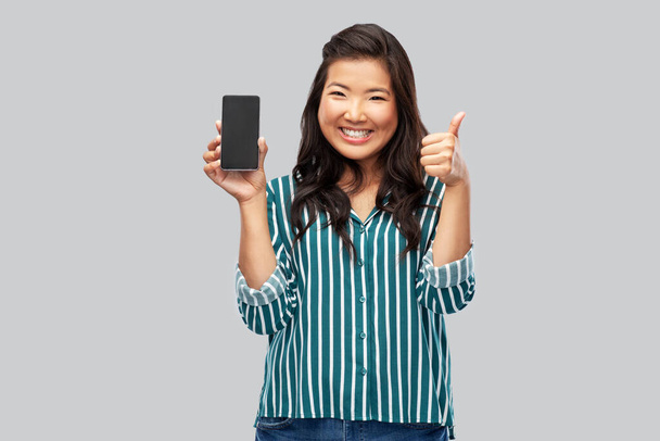 happy asian woman with smartphone shows thumbs up - Zdjęcie, obraz
