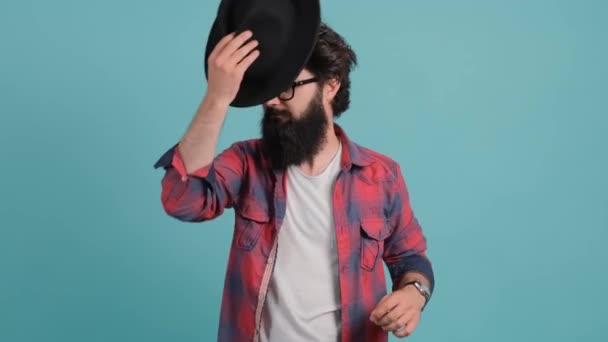 Bearded man in casual outfit and glasses. He smiling, and putting a hat on. - Footage, Video